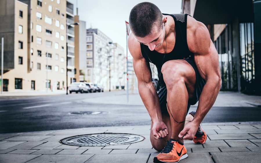 Runner kneeling on a city sidewalk tying bright running shoes before a workout